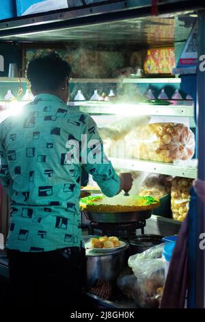 Une photo d'un vendeur de rue vendant bhel puri dans les rues indiennes (Bhelpuri est un snack salé originaire de l'Inde, et est aussi un type de chaat) Banque D'Images