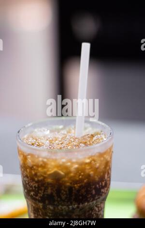 Un gros plan de coke avec de la glace et de la paille dans un verre Banque D'Images