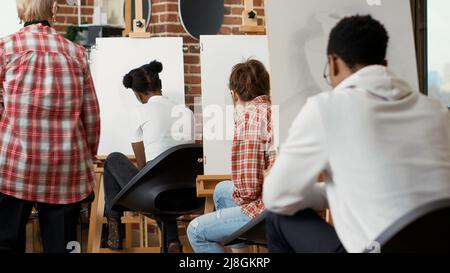 Artiste aîné aidant jeune étudiant avec le dessin de modèle de vase dans l'atelier de création, assistant à la classe d'art pour développer de nouvelles compétences artistiques. Création d'œuvres d'art contemporaines pour votre épanouissement personnel. Banque D'Images