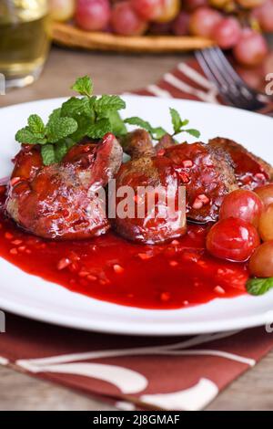 Salade chaude avec foie de poulet et raisins sur l'assiette.Salade chaude de foie de dinde.Salade chaude avec foie de poulet et sauce à la framboise. Banque D'Images