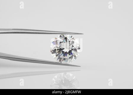 Diamant tenu dans Tweezers. Photographie horizontale en diamant avec réflexion. Banque D'Images