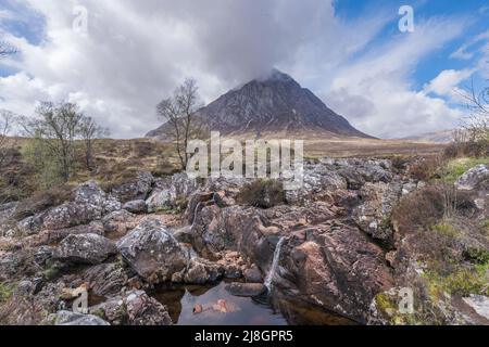Le sommet rocheux de Buachaville Etive Mòr vue au-dessus d'un ruisseau en cascade à travers le grès rouge Banque D'Images
