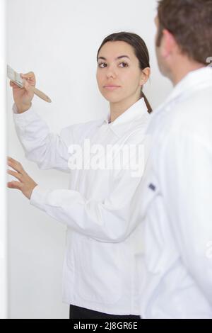 femme peignant le bord du mur avec la brosse Banque D'Images