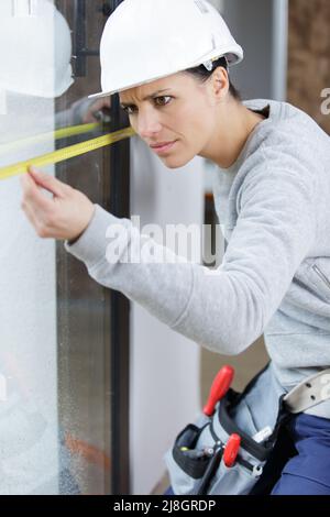 femme avec outil de mesure de niveau sur le chantier de construction Banque D'Images