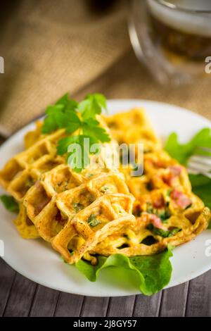 Omelette aux œufs farcie avec des légumes verts et des saucisses frits sous forme de gaufres, sur une table en bois Banque D'Images