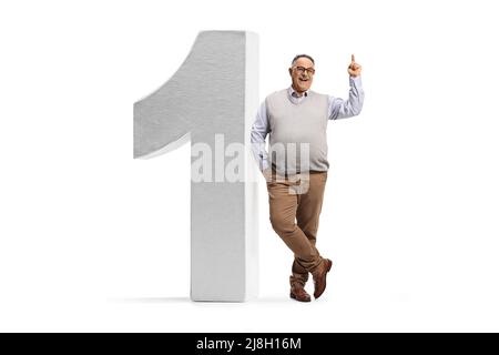 Portrait en longueur d'un homme mûr gai pointant vers le haut et penché sur un grand numéro un isolé sur fond blanc Banque D'Images
