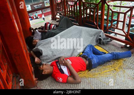 Un groupe d'enfants sans abri dort sur le pont à pied à Dhaka, au Bangladesh, le 16 mai 2022 Banque D'Images