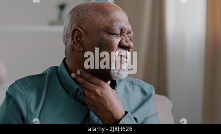 Un vieil homme africain malade souffre d'un mal de gorge irritation douloureuse de l'amygdalite chez l'homme senior laryngite à l'intérieur de la glande noire infections bactériennes maladies Banque D'Images