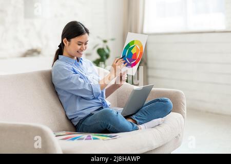 Une femme heureuse travaillant à la maison, ayant le chat vidéo avec le client Banque D'Images