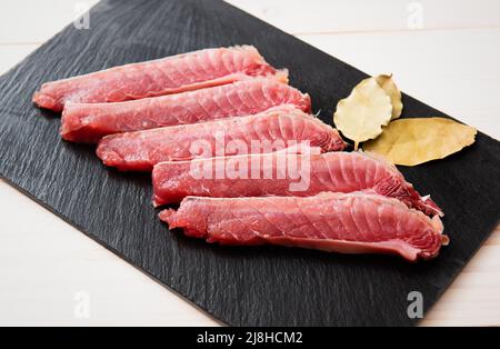 Thon sashimi sur un panneau en pierre. Arrière-plan noir. Vue de dessus. Banque D'Images