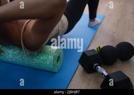 La femme fait des exercices couchés sur le rouleau et l'équilibrage Banque D'Images