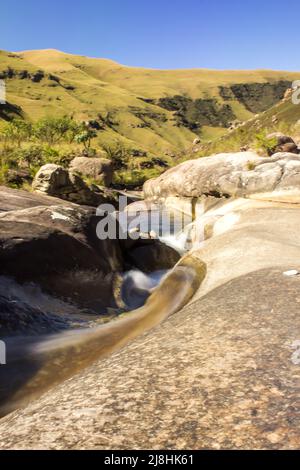 Longue exposition d'un ruisseau de montagne à écoulement rapide dans les montagnes du Drakensberg en Afrique du Sud, par une journée ensoleillée Banque D'Images