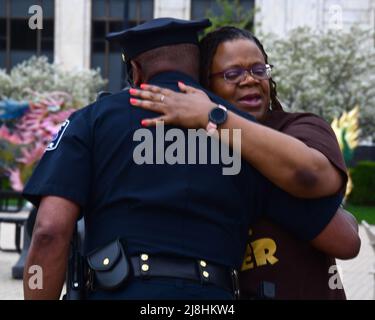 Racine, Wisconsin, États-Unis. 15th mai 2022. QUASHANA ENCOURAGE les hugs du chef de police de racine MAURICE ROBINSON avant une vigile pour la paix à racine et dans le monde dimanche soir 15 mai 2022 sur Monument Square dans le centre-ville de racine, Wisconsin. La vigile a été organisée par la Coalition interconfessionnelle racine. Deux personnes ont été abatillées, une mortellement, tôt le dimanche dans le quartier des affaires de Uptown, mais la veillée avait été prévue il y a quelques jours. (Image de crédit : © Mark Hertzberg/ZUMA Press Wire) Banque D'Images