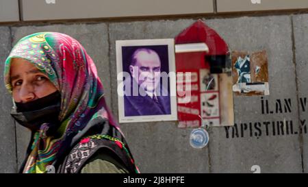 Izmir, Turquie. 15/05/2022, les gens occasionnels marchent et passent devant un miroir avec le reflet d'un drapeau turc et l'affiche d'Ataturk sur le mur de la rue dans la vie quotidienne d'Izmir, Turquie. Banque D'Images