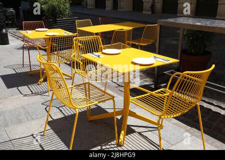 Café en Pologne. Warsaw, Pologne - café hippster moderne avec chaises en acier jaune et table à l'extérieur. Banque D'Images