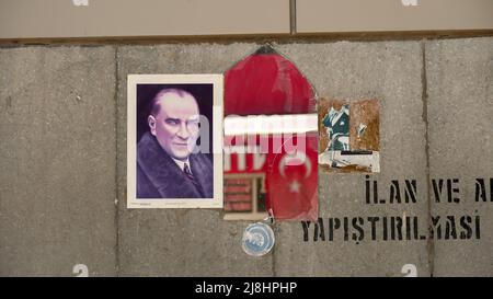 Izmir, Turquie. 15/05/2022, les gens occasionnels marchent et passent devant un miroir avec le reflet d'un drapeau turc et l'affiche d'Ataturk sur le mur de la rue dans la vie quotidienne d'Izmir, Turquie. Banque D'Images