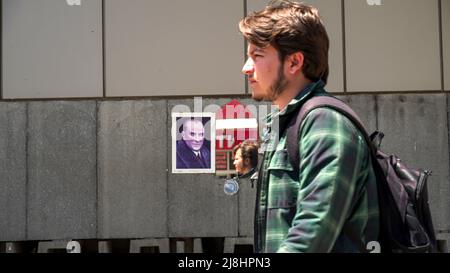 Izmir, Turquie. 15/05/2022, les gens occasionnels marchent et passent devant un miroir avec le reflet d'un drapeau turc et l'affiche d'Ataturk sur le mur de la rue dans la vie quotidienne d'Izmir, Turquie. Banque D'Images