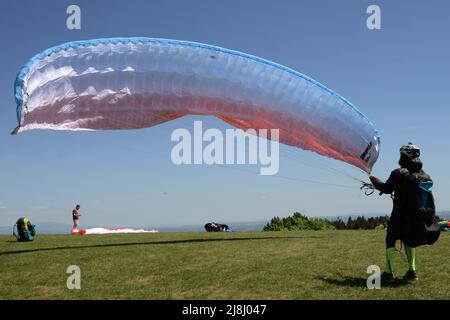 Kozakov, République tchèque. 16th mai 2022. Un parapente se prépare à partir d'un Kozakov (à 100 kilomètres au nord de Prague) pendant une journée ensoleillée dans le Paradis tchèque. Le parapente est un sport de vol de loisir et de compétition. Le pilote est assis dans un harnais suspendu sous une aile en tissu, dont la forme est formée par la pression de l'air entrant dans les évents à l'avant de l'aile. (Credit image: © Slavek Ruta/ZUMA Press Wire) Banque D'Images