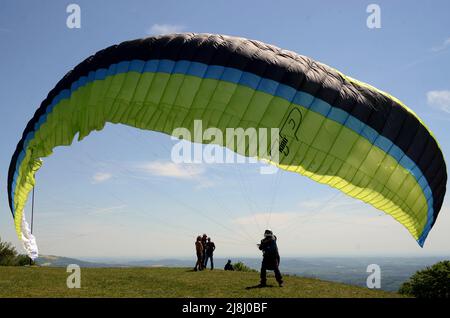 Kozakov, République tchèque. 16th mai 2022. Un parapente se prépare à partir d'un Kozakov (à 100 kilomètres au nord de Prague) pendant une journée ensoleillée dans le Paradis tchèque. Le parapente est un sport de vol de loisir et de compétition. Le pilote est assis dans un harnais suspendu sous une aile en tissu, dont la forme est formée par la pression de l'air entrant dans les évents à l'avant de l'aile. (Credit image: © Slavek Ruta/ZUMA Press Wire) Banque D'Images