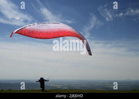 Kozakov, République tchèque. 16th mai 2022. Un parapente se prépare à partir d'un Kozakov (à 100 kilomètres au nord de Prague) pendant une journée ensoleillée dans le Paradis tchèque. Le parapente est un sport de vol de loisir et de compétition. Le pilote est assis dans un harnais suspendu sous une aile en tissu, dont la forme est formée par la pression de l'air entrant dans les évents à l'avant de l'aile. (Credit image: © Slavek Ruta/ZUMA Press Wire) Banque D'Images