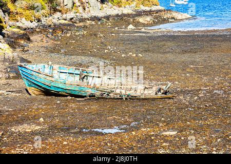 Bateau de pêche naufragé sur le Loch Carron avec une vue imprenable sur le village pittoresque de Plockton, le joyau des Highlands, en Écosse Banque D'Images