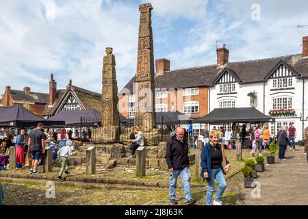 Les gens au marché des fermiers et des fabricants autour des croix saxonnes anciennes sur la place du marché pavée de la ville de marché Cheshire de Sandbach en Angleterre Banque D'Images