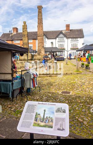 Les gens au marché des fermiers et des fabricants autour des croix saxonnes anciennes sur la place du marché pavée de la ville de marché Cheshire de Sandbach en Angleterre Banque D'Images