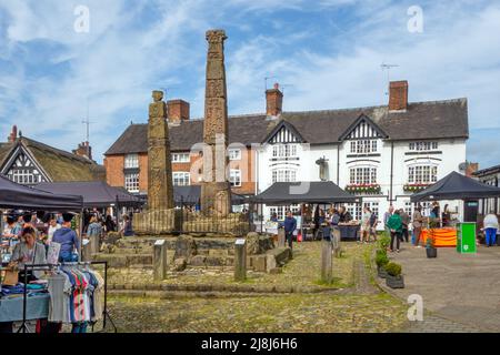 Les gens au marché des fermiers et des fabricants autour des croix saxonnes anciennes sur la place du marché pavée de la ville de marché Cheshire de Sandbach en Angleterre Banque D'Images