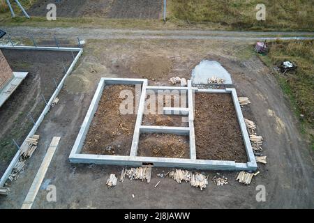 Vue aérienne de haut en bas des travaux de construction de la fondation en béton de la maison neuve sur le chantier de construction Banque D'Images