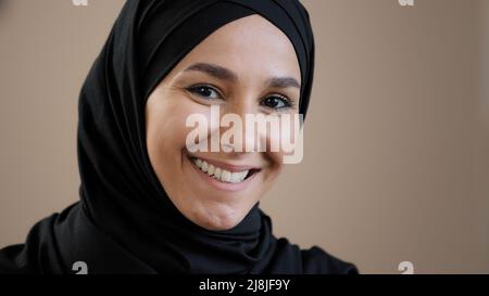 Portrait en gros plan d'une jeune femme arabe musulmane de 30s ans portant un foulard hijab traditionnel en posant avec confiance le regard sur l'appareil photo Banque D'Images