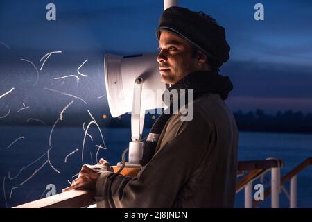 Membre du crem sur un bateau Dahabiya du Nil la nuit près de la lumière du spot Banque D'Images
