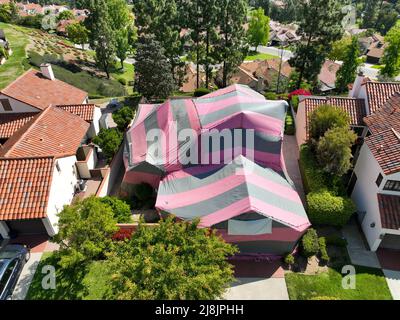 Villa couverte avec une tente rouge et grise tout en étant fumigation pour termites, San Diego, Californie, Etats-Unis. 17th avril 2022 Banque D'Images