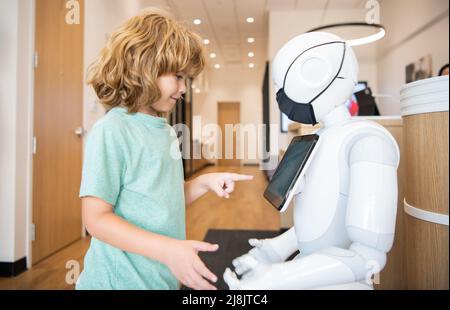 un petit garçon interagit avec l'intelligence artificielle du robot, la communication Banque D'Images
