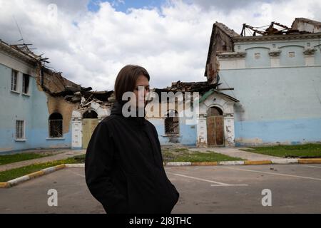 Kiev, Ukraine. 17th mai 2022. Un civil passe devant un bâtiment détruit à Bucha. La ligne de front Russie-Ukraine étant repoussée vers l'est et le Sud-est, l'outjupe autrefois occupée par les Russes de Kiev comme Bucha, Borodyanka et Hostomel doit maintenant être reconsidérée au monde. Les voitures, les bâtiments, les chars détruits et même le plus grand avion du monde sont parmi les victimes de la guerre. Crédit : SOPA Images Limited/Alamy Live News Banque D'Images