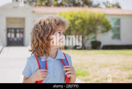 De retour à l'école, un bon garçon sur le chemin de l'école. Enfant avec sacs à dos debout dans le parc près de l'école. Banque D'Images