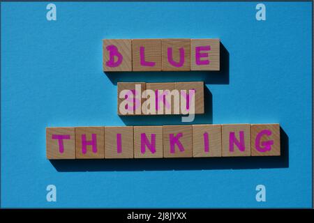 Blue Sky Thinking, mots en lettres de l'alphabet en bois isolées sur fond bleu Banque D'Images