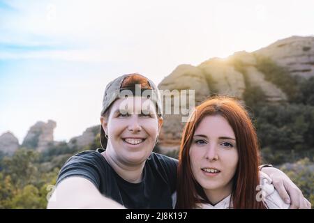 deux jeunes filles et randonneurs, prenant un selfie du haut de la montagne avec leur smartphone. concept passe-temps et voyage. Banque D'Images