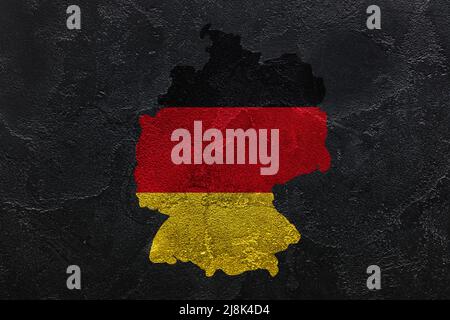 Carte peinte de l'Allemagne en couleurs de drapeau national sur fond de grunge foncé Banque D'Images