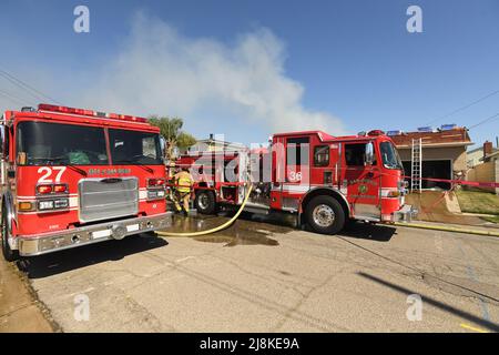 Un incendie dans une maison dans le quartier de Kearny Mesa à San Diego a donné lieu à une première affectation d'alarme des pompiers de secours de San Diego. Le feu en mouvement rapide a détruit la section vivante de la maison, avec seulement le garage survivant aux flammes. Après un effondrement complet du toit au-dessus des quartiers de vie, les pompiers ont dû utiliser une échelle aérienne pour finir d'éteindre les flammes. Les deux occupants de la maison se sont échappés en toute sécurité . La cause de l'incendie a été déterminée comme étant des travaux récents sur le toit de la structure et le montant total des dommages a été fixé à $400 000 USD. Banque D'Images