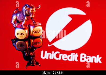 Le taureau métallique se dresse sur des dés d'achat-vente sur le fond du logo de la banque UniCredit Banque D'Images