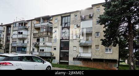 Umag, Croatie, 5 mai 2022: Vieux bloc d'appartements de l'ère socialiste de Yougoslavie avec un escalier en verre et de petits balcons Banque D'Images