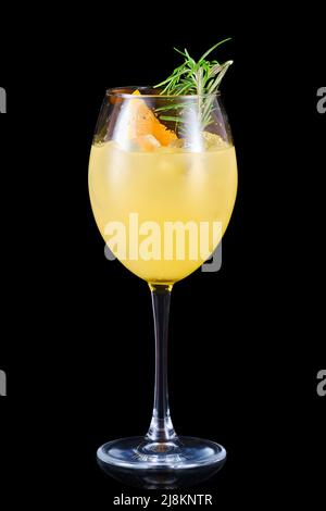 Limonade d'orange froide au parfum de romarin dans un verre de vin isolé sur fond noir Banque D'Images