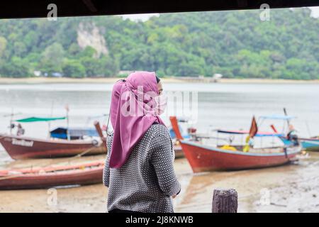 Une femme musulmane portant le hijab et se tenant à la plage Banque D'Images