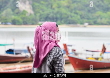 Une femme musulmane portant le hijab et se tenant à la plage Banque D'Images
