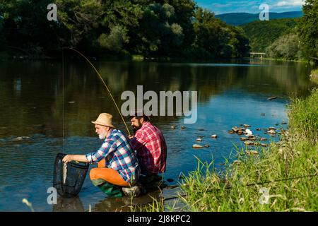 Pêcheurs hommes amis et truite trophée. Père et fils de pêche. Générations hommes pêche dans la rivière. Banque D'Images