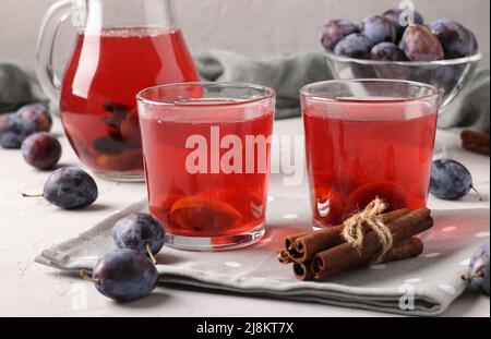 Compote de prune en pot et deux verres sur fond gris clair Banque D'Images