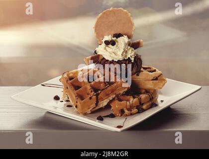 Gaufres belges avec glace et chocolat sur une assiette blanche dans un café Banque D'Images