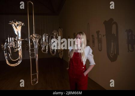 Londres, Royaume-Uni. 17 mai 2022. Un membre du personnel pose avec 'Perpetual Canon', 2004, par Cornelia Parker à l'avant-première d'une nouvelle exposition de Cornelia Parker à Tate Britain. Il s’agit de la première grande enquête sur les œuvres de l’artiste à Londres avec plus de 90 expositions couvrant des installations, des sculptures, du film, de la photographie et des dessins dans un spectacle qui se déroule du 18 mai au 16 octobre 2022. Credit: Stephen Chung / Alamy Live News Banque D'Images