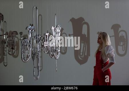 Londres, Royaume-Uni. 17 mai 2022. Un membre du personnel pose avec 'Perpetual Canon', 2004, par Cornelia Parker à l'avant-première d'une nouvelle exposition de Cornelia Parker à Tate Britain. Il s’agit de la première grande enquête sur les œuvres de l’artiste à Londres avec plus de 90 expositions couvrant des installations, des sculptures, du film, de la photographie et des dessins dans un spectacle qui se déroule du 18 mai au 16 octobre 2022. Credit: Stephen Chung / Alamy Live News Banque D'Images