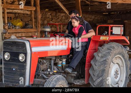 Image du père enseignant son tracteur à sa fille avec sa fille. Banque D'Images